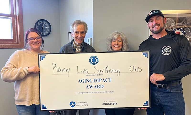 Two woman and two men holding oversized certificate