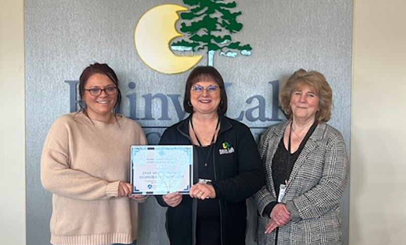 Three smiling woman holding certificate.