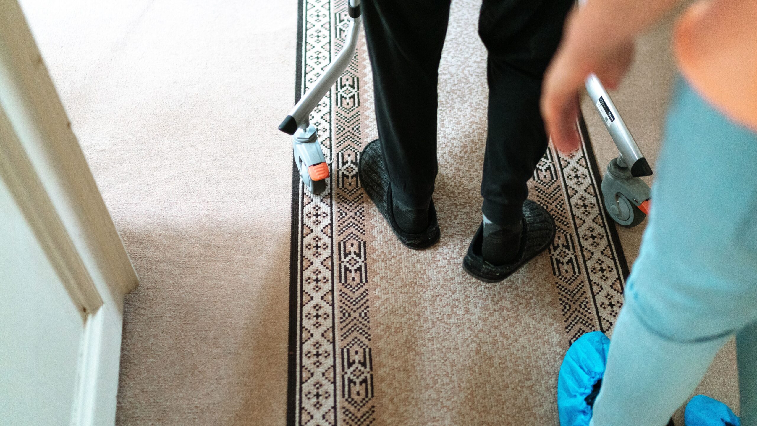 feet walking with a walker and an aide's feet behind