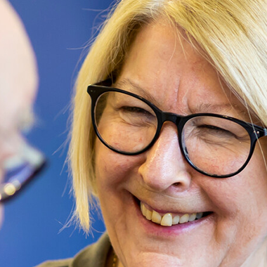 Smiling older woman with blond hair and glasses
